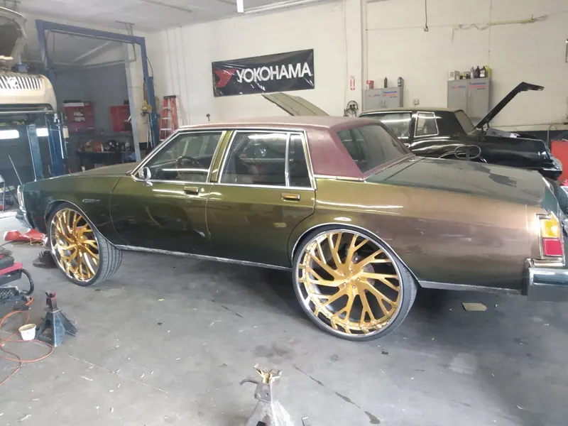 A car in the bay at Big Boyz Auto Center during work